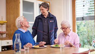 Malteser Mitarbeiterin liefert Essen und spricht mit einem Ehepaar
