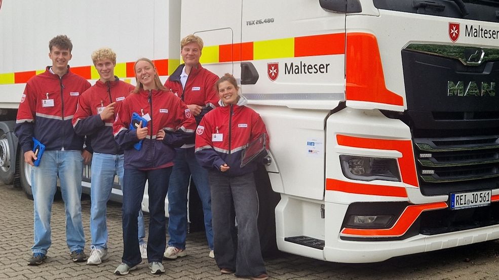 Fünf junge Leute in Malteser Kleidung stehen vor dem Auslands-LKW der Malteser in Bad Reichenhall