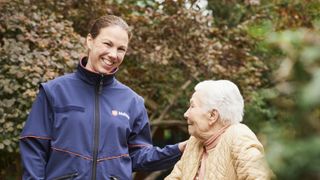 Junge und alte Frau spazieren gemeinsam