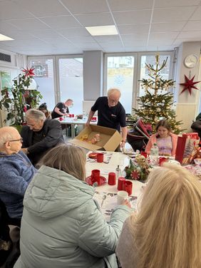 Einer der Ehrenamtlichen verteilt Lebensmittel an die Anwesenden.