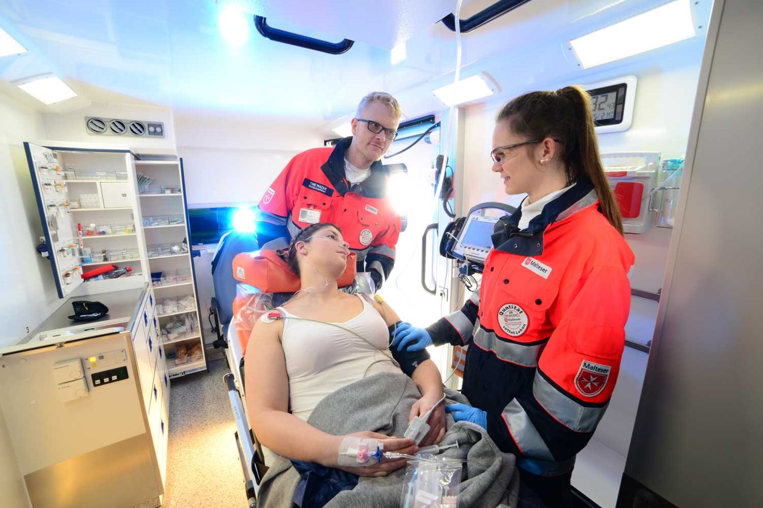 Rettungssanitäter der Malteser versorgen eine Frau im Rettungswagen.