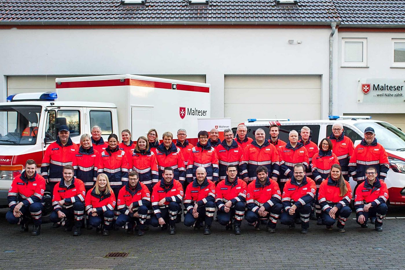 Gruppenfoto der Malteser in Steinhaus vor ihren Einsatzfahrzeugen