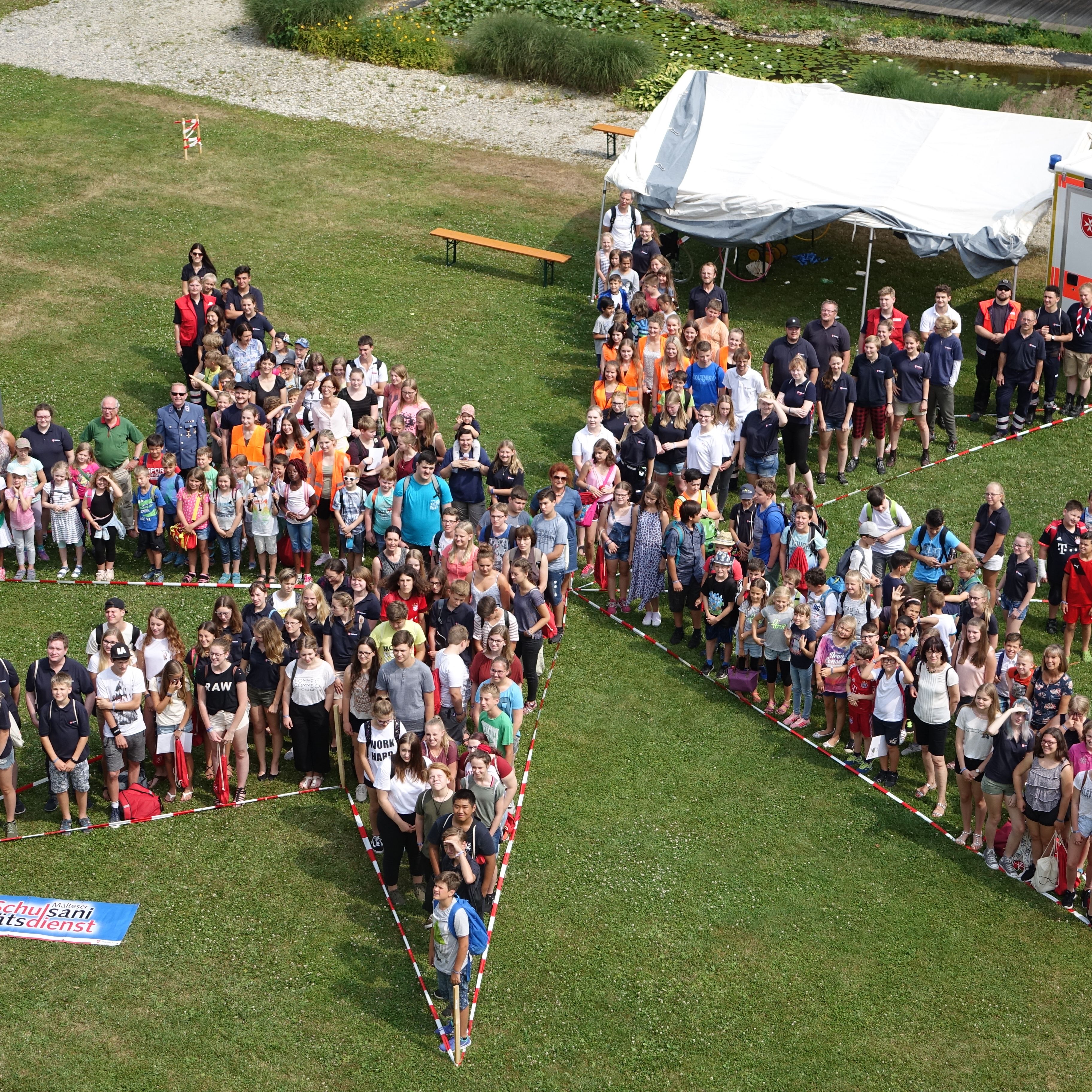 Gruppenbild der Malteser Jugend in Form des Malteser-Kreuzes