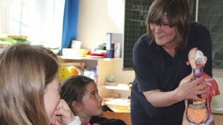 Eine Malteser Mitarbeiterin unterrichtet Kinder über die Erste-Hilfe.