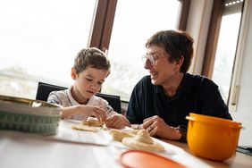 Eine Hospizbegleiterin beim Spielen mit einem Jungen