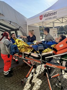 In dieser simulierten Situation wird ein Verletzter auf einer Trage ins Behandlungszelt gebracht. 