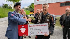 Zwei Männer halten gemeinsam einen symbolischen Spendenscheck 