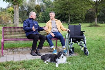 Zwei Männer sitzen auf einer Bank und reden. Foto: Kirchner