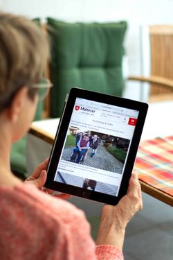 Eine Frau hält ein Tablet in der Hand 