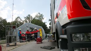 Malteser-Fahrzeug vor einem Zelt