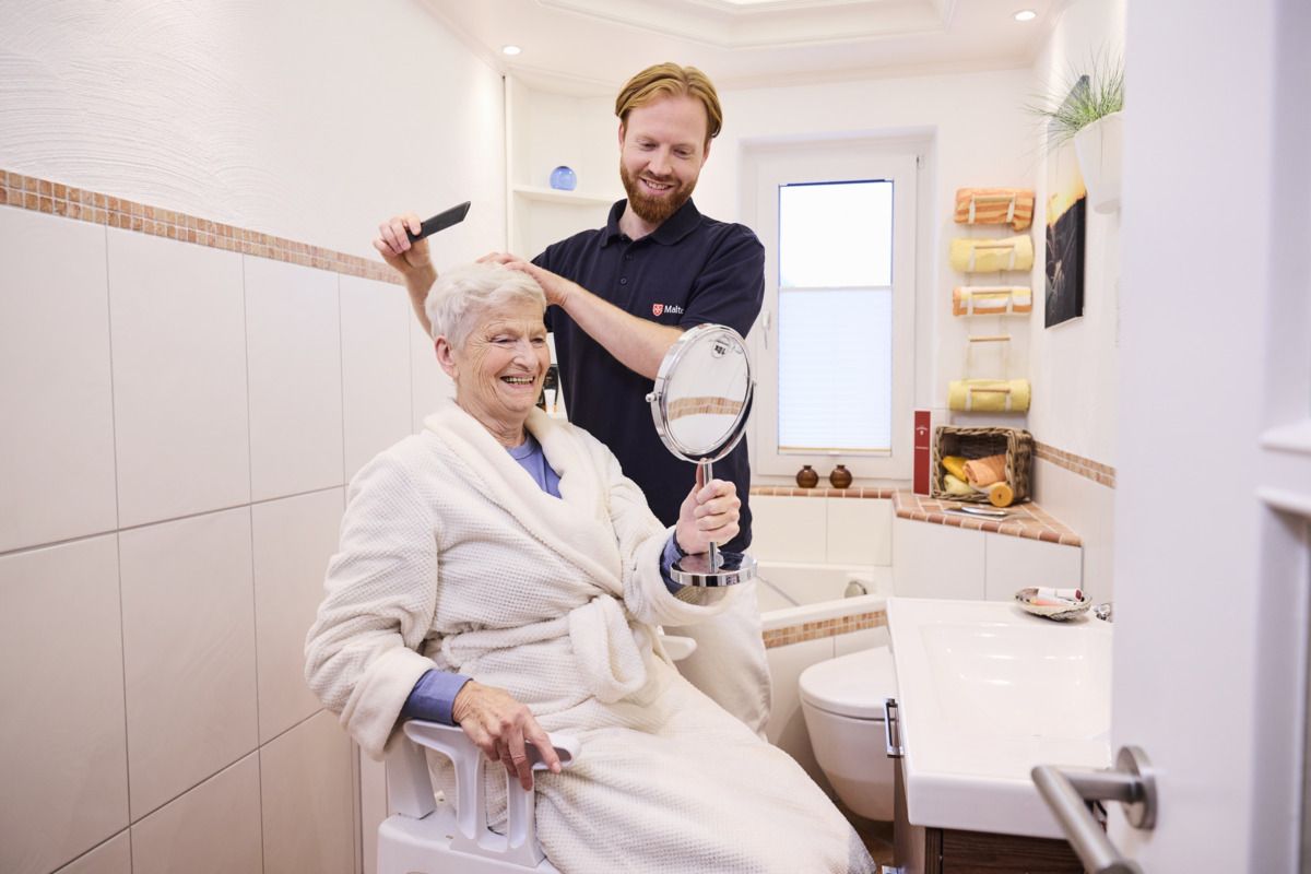 Ein Pfleger kämt die Haare der Frau