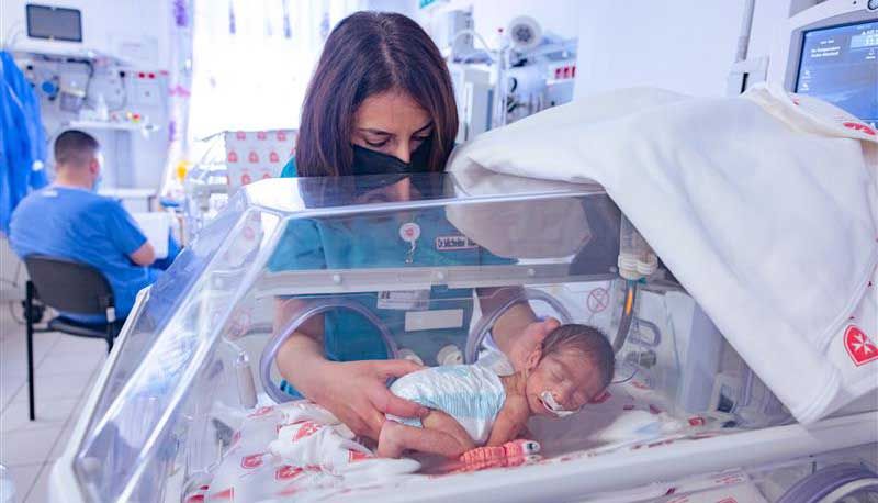 Eine Frau mit einem Baby in einer Frühchenstation 