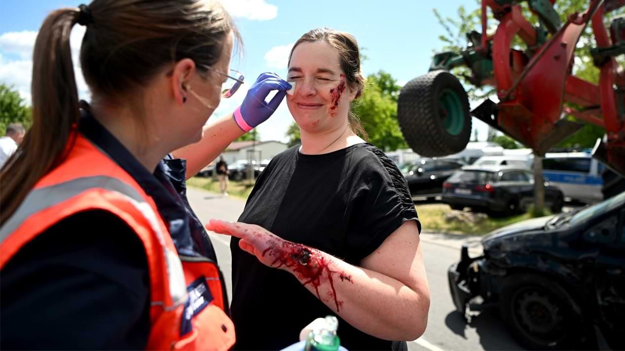 Eine Frau schminkt einer andern Frau Verletzungen an Arm und im Gesicht die durch einen Autounfall entstanden sein könnten