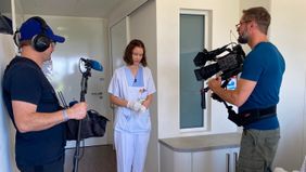Kamerateam mit zwei Personen filmt und interviewt eine Pflegekraft.