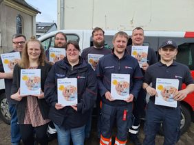 Eine Gruppe Malteser hält die Notfallmappe in Händen