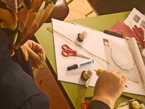 Geflüchtete und Malteser Ehrenamtliche basteln gemeinsam.