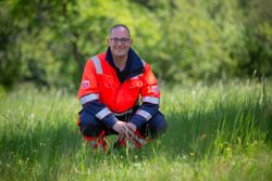 Auf dem Foto ist ein Helfer in Einsatzkleidung zu sehen. 