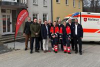 Vertreter von Landkreis Fulda, Gemeinde Hosenfeld und Malteser Rettungsdienst Hessen vor dem neuen Rettungswachenstandort Hosenfeld. Im Hintergrund ist ein Rettungswagen zu sehen.