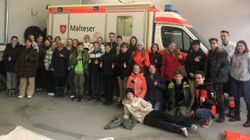Viele Schüler stehen vor einem Malteser Rettungswagen.