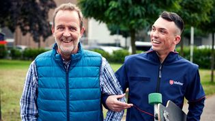 Mann und Malteser Helfer gehen gemeinsam spazieren