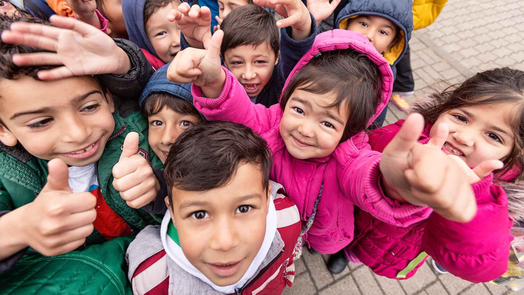 Kinder schauen in die Kamera und freuen sich