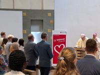 Die Besucher der Verabschiedung sitzen in der Messe, während Diözesanseelsorger Harald Niermann alle Anwesenden begrüßt