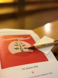 Das Liedheft mit Stift und Fürbittenkärtchen liegen auf einer Bank. Dies ist in der Christuskirche in Cottbus.