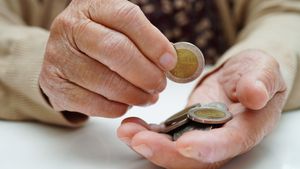 Eine Hand, in der mehrere Zwei-Euro-Geldstücke liegen.