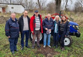Eine Gruppe von Menschen vor einem Traktor