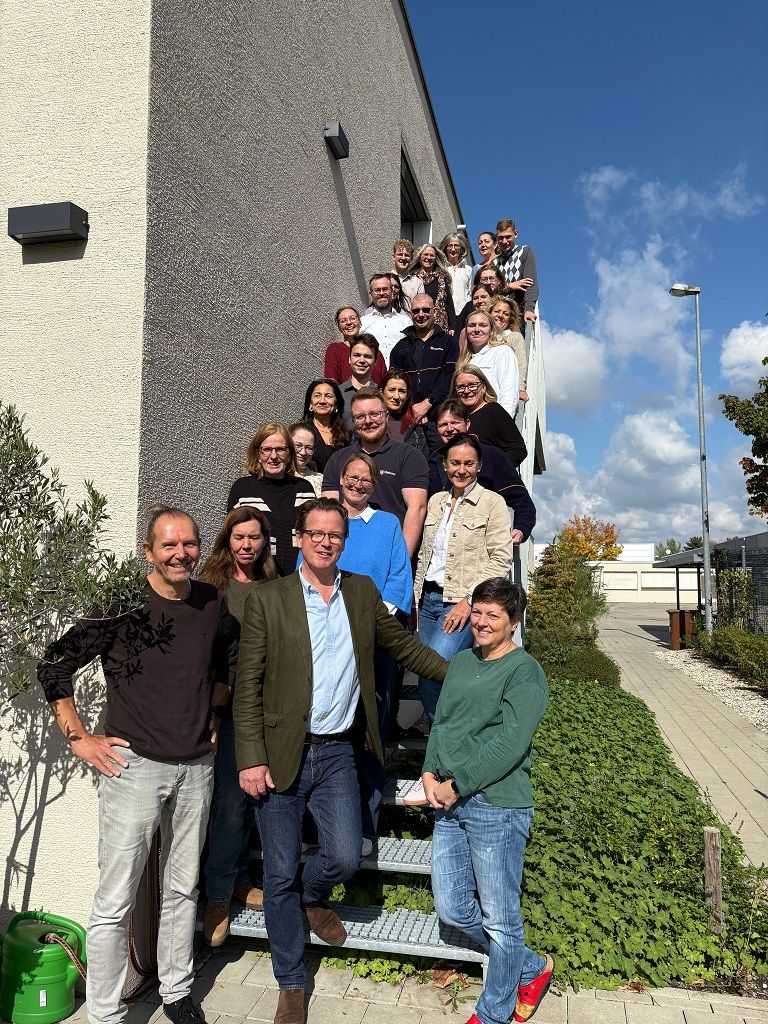 Alle Mitarbeiter stehen an einer Treppe