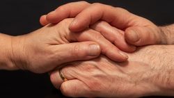 zwei Hände umschließen eine andere Hand