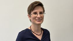 Eine junge Frau lächelt in die Kamera.