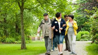Eine Gruppe spaziert durch einen Wald.