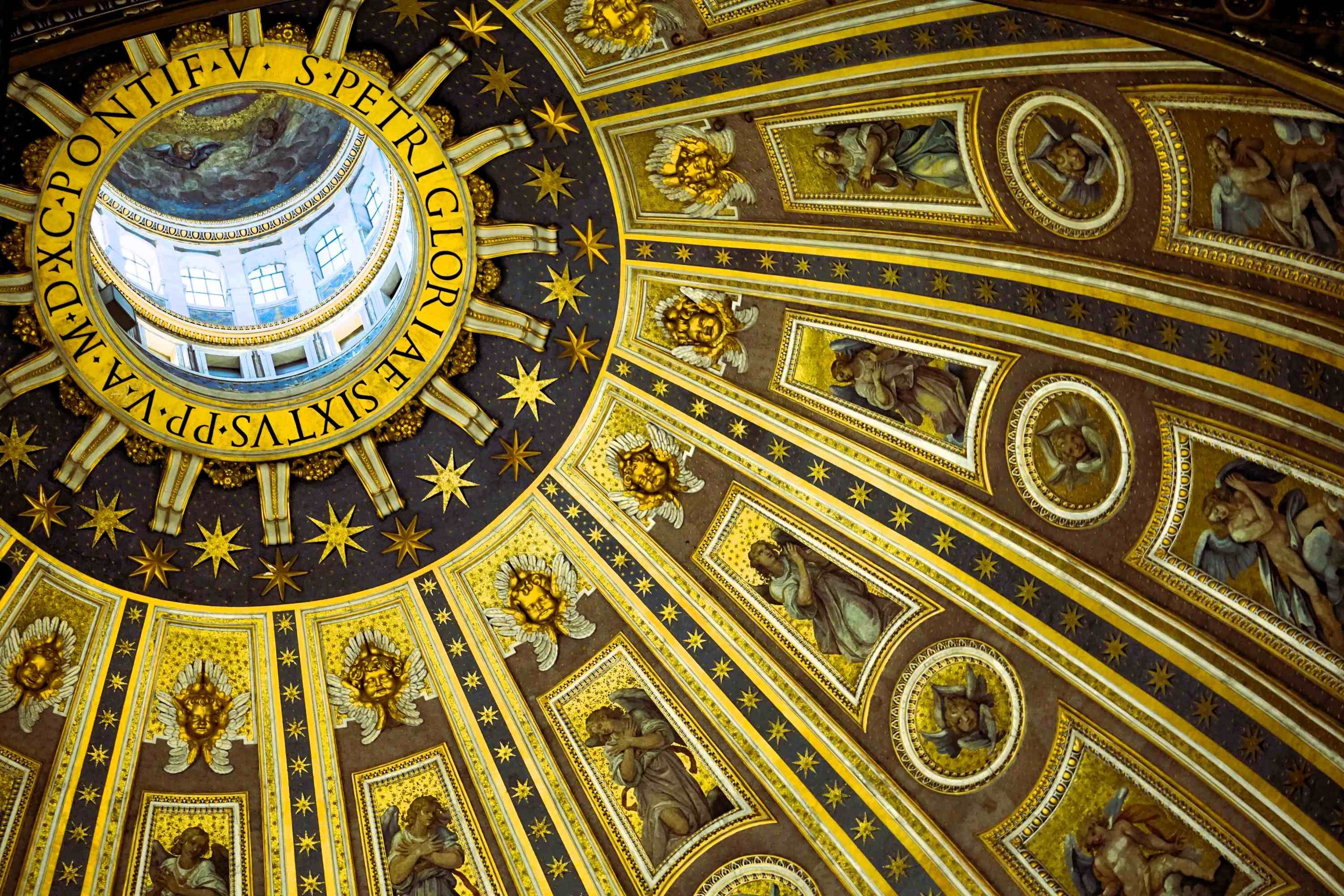 Innenansicht einer reich verzierten Kuppel mit goldfarbenen und schwarzen Mustern und einem runden Fenster in der Mitte.