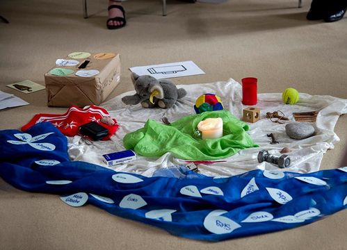 Ein Tuch mit verschiedenen Symbolen zum Thema Trauer liegt auf dem Boden