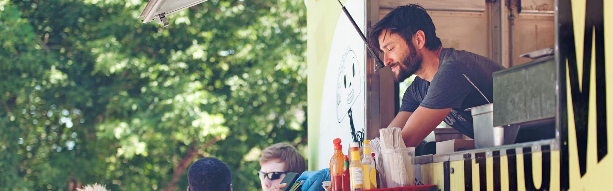 Mann bedient ältere Dame aus einem Foodtruck