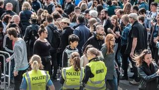 Eine Menschenmenge. Im Vodergrund die Polizei.