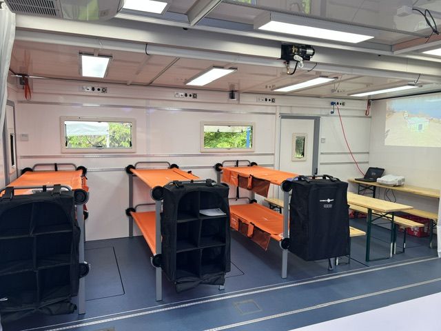 Innenansicht des MedExTainer mit mehreren aufgebauten Doppelstockbetten in Orange