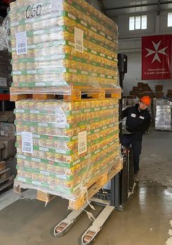 Dieses Bild zeigt einen ukrainischen Helfer der Malteser im Logistikzentrum Lviv beim Entladen der Hilfsgüter.