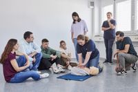 Eine Gruppe junger Menschen lernt die Herzdruckmassage