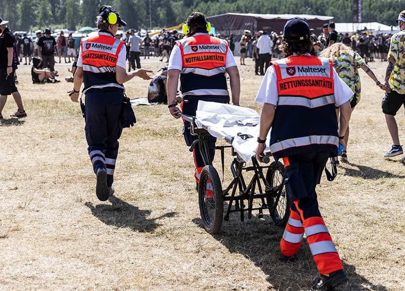 Malteser Sanitäter sind auf einem Musikfestival auf dem Weg zu einem Einsatz.