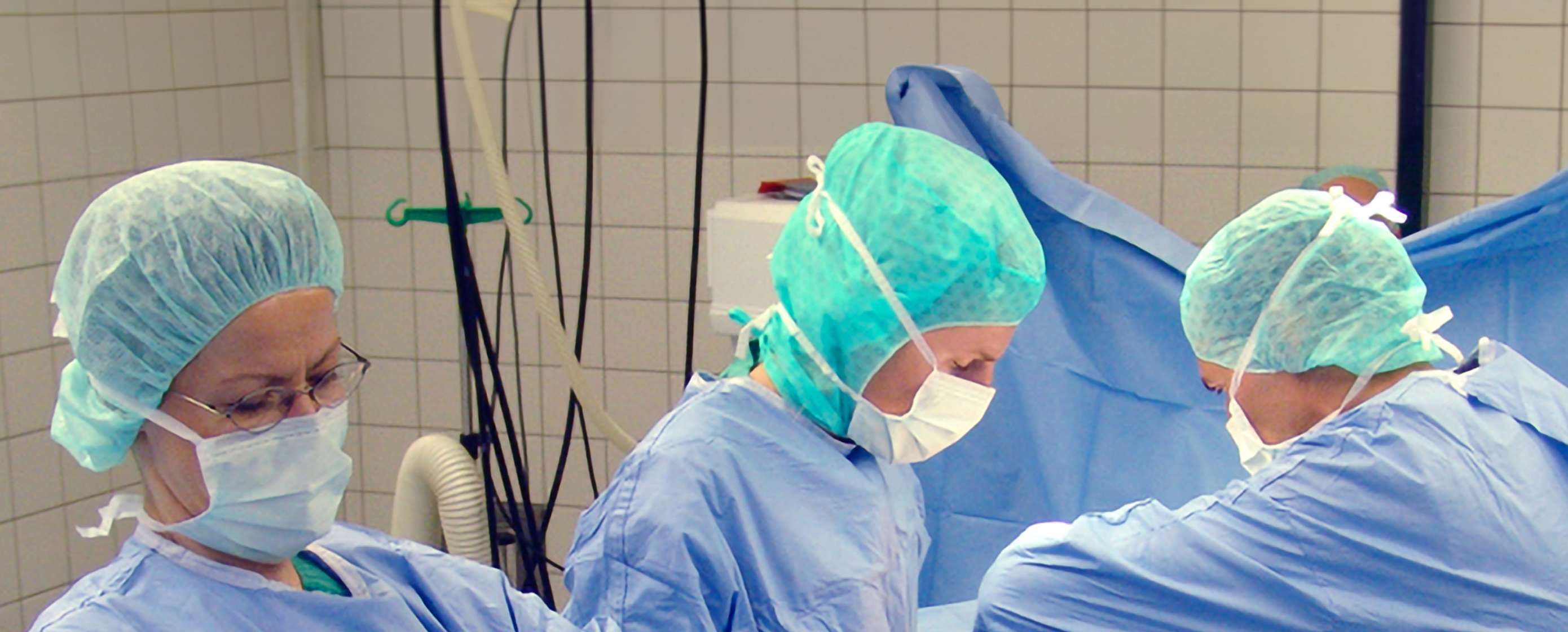 Drei Mitarbeitende der Gefäßchirurgie operieren im OP-Saal. 