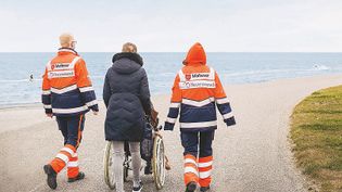Ehrenamtliche begleiten einen Menschen am Lebensende zu einem letzten Ausflug ans Meer. Foto: Bettina Fürst-Fastré