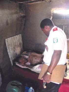 A care team worker visits a patient at his bedside.