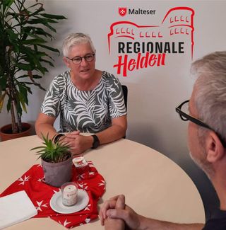 Heidi im Gespräch an einem runden Tisch