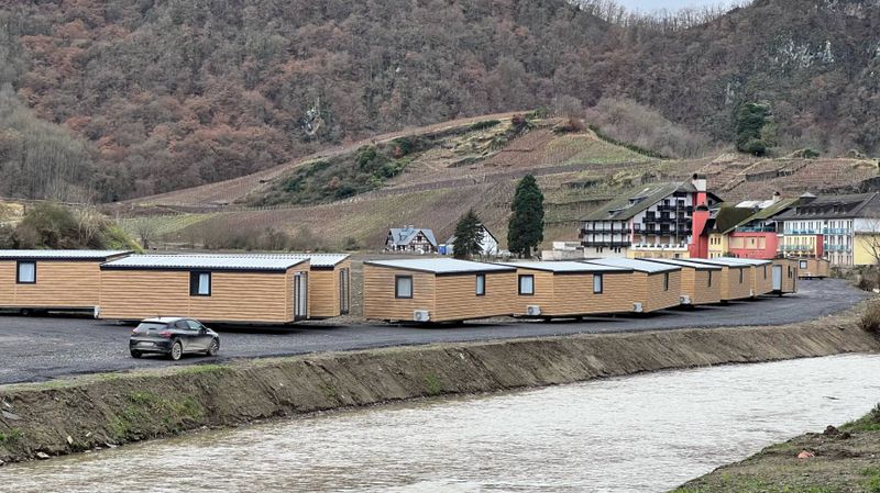 Tiny Houses stehen am Bahnhof von Mayschoß bereit, im Hintergrund Weinberge.