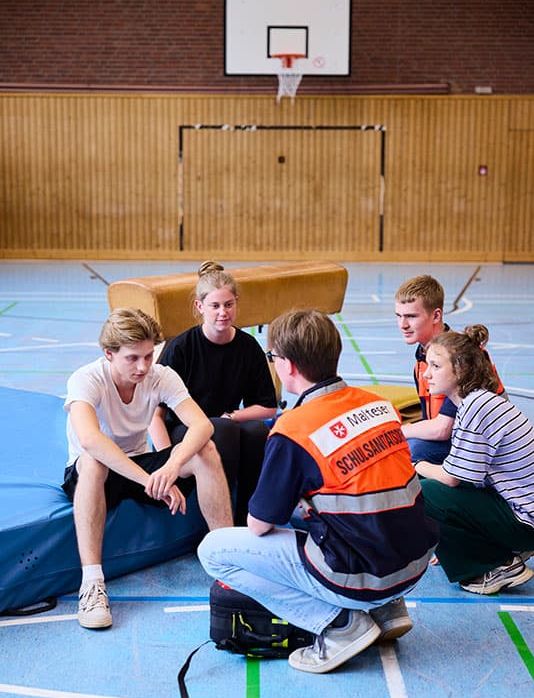 Malteser Schulsanitäter versorgen Schüler im Sportunterricht