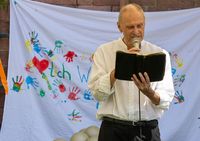 Stephan Skroch stehend auf einer Wiese mit Buch (Foto: Malteser Mainz)