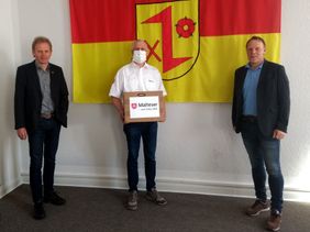 Klaus Möllers, stv. Stadtbeauftragter und Leiter der SEG Dinklage, übergibt 150 Behelfsmasken an Bürgermeister Frank Bittner (rechts) und Alfons Echtermann (links), Stadt Dinklage. Foto: Claudia Möllers