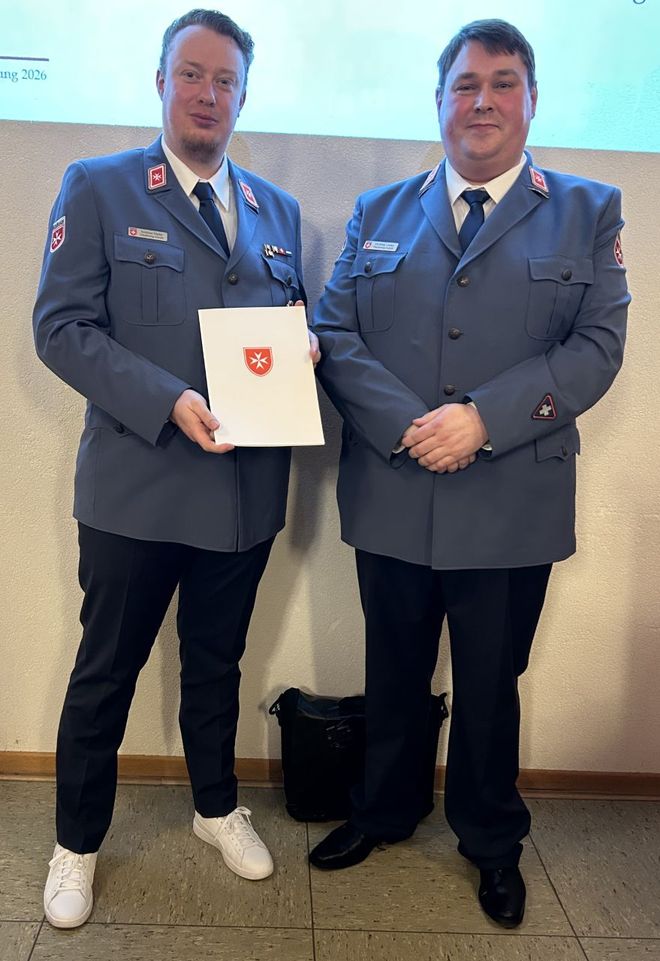 Andreas Töpfer und Matthias Lieske posieren in Malteser Dienstanzügen für das Foto